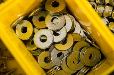 Kleine Beilagscheiben in einer gelben Box