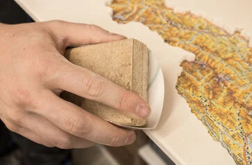 Schleifen eines Holzpuzzles von Hand